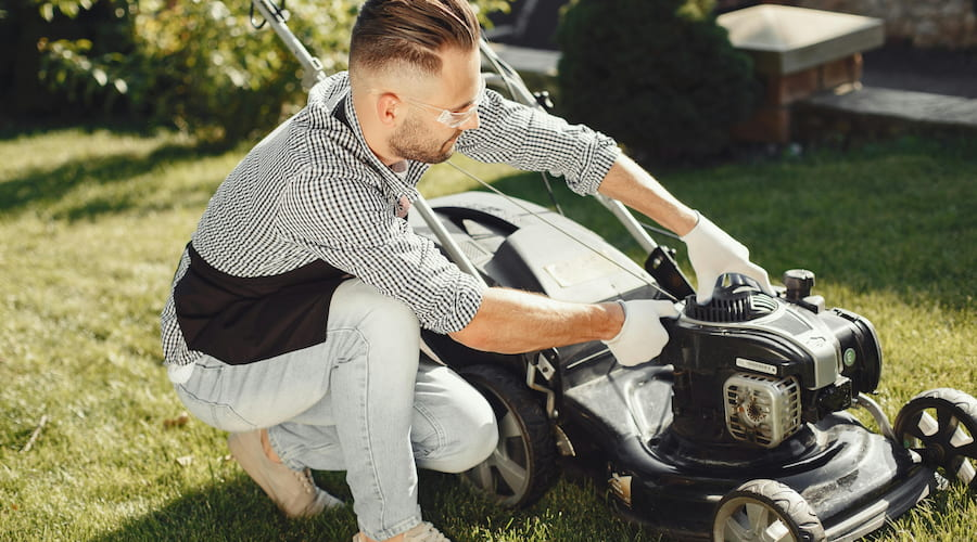 Mann repariert Rasenmäher